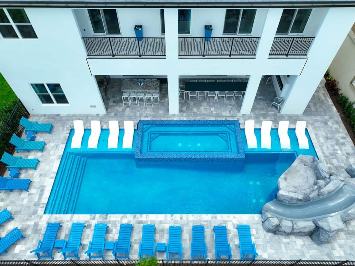 Aerial dusk view of The Most Fun House with a large pool, spa, and outdoor living spaces.