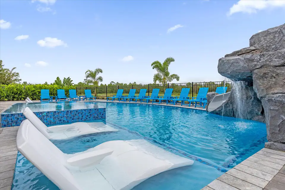 An Orlando vacation home and turquoise pool beneath a bright blue sky.